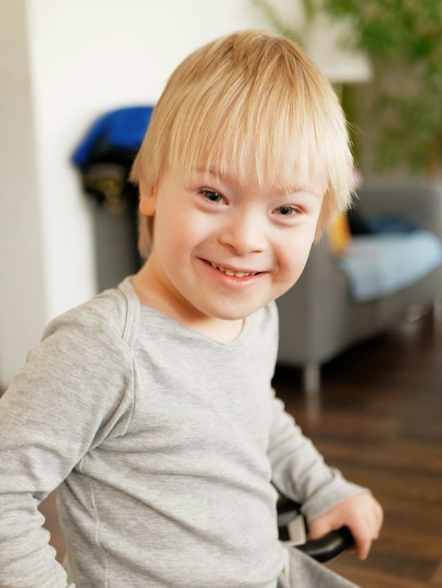 A young kid on a chair smiling